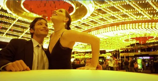 A couple in evening wear at a brightly lit casino