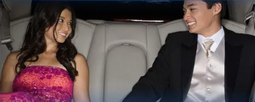 A prom couple seated in a white leather limousine