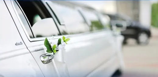 The door of a white limousine decorated with white flowers